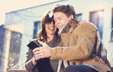 Young couple having fun with mobile phone on a sunny day