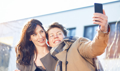 Young couple having fun with mobile phone on a sunny day