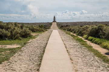 Leuchtturm an der Algarve, Portugal hinter leuchtenden grün, roten Pflanzen