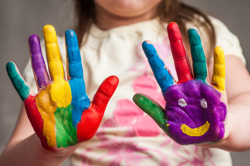 Girl with hand painted in colorful paints