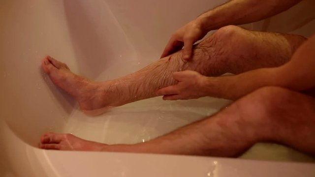Man is sitting in bath and washed wound
