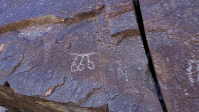 A close up pan of petroglyphs carved into rock