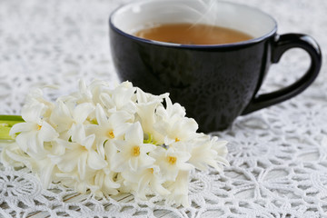 Cup of green tea, color macaroon and white flowers