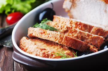 Baked meat with olive on the wooden table