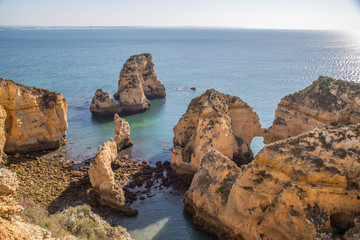 Fototapeta na wymiar Traumhafte leuchtende Felsen an der Algarve Küste mit menschenleeren Stränden und blühenden Landschaften
