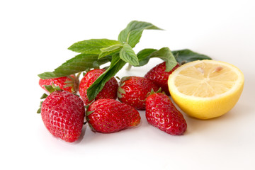 Organic strawberries with lemon and mint on a white background
