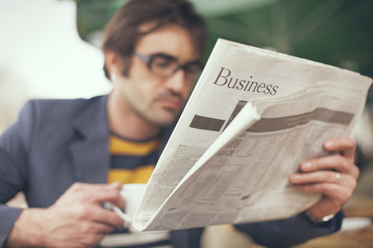 Close up of man reading business section of newspaper