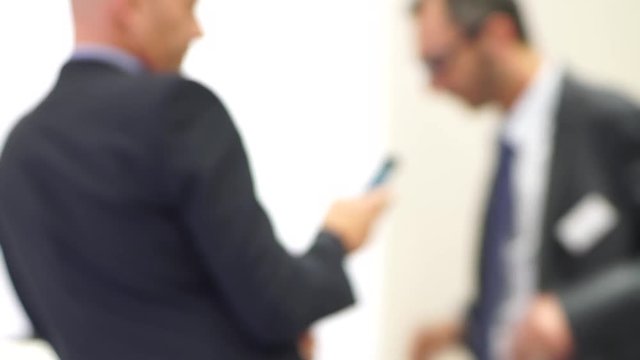 M&auml;nner in Businesskleidung am Smartphone mit Slidereffekt