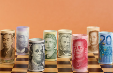 Currency War. Chess Dressed in Different Banknotes on a Chess Board.
