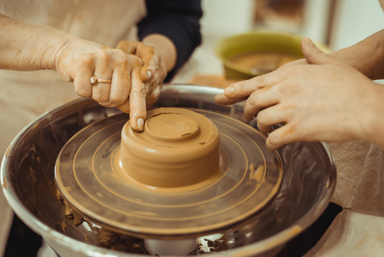 teacher and student work on the potter's wheel