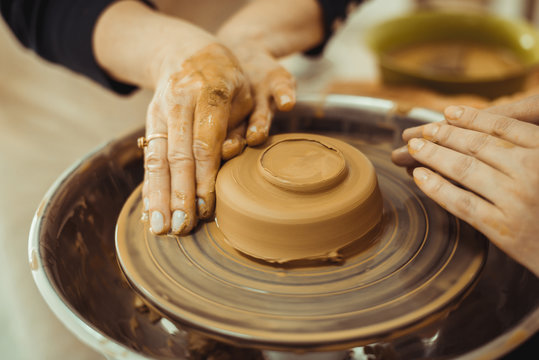 teacher and student work on the potter's wheel