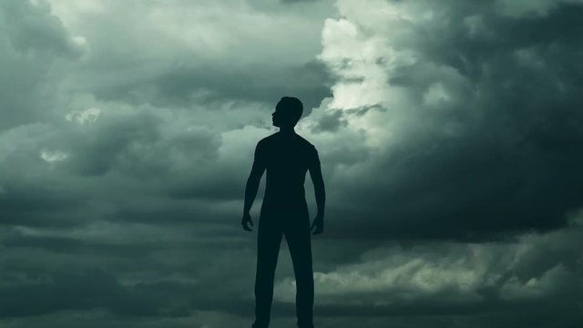 The man stand against the background of volume cloud. Time lapse. Wide angle