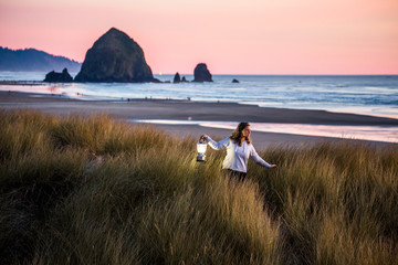 Caucasian woman carrying lantern on Cannon Beach, Oregon, United States