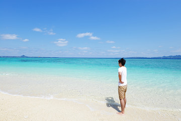 Fototapeta na wymiar 沖縄の美しい海でくつろぐ男性