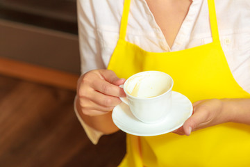 Woman holding cup of coffee in kitchen.