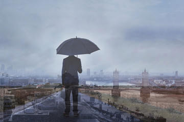 double exposure photo of business man with umbrella and London skyline, panoramic view of the city