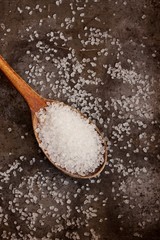 Sea salt in a wooden spoon close up view from top