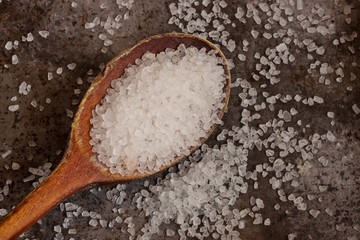 Sea salt in a wooden spoon close up view from top