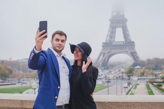 couple of tourists taking photo with Eiffel Tower in Paris, selfie, tourism in Europe, France