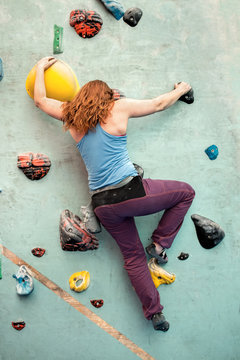 Redhead Woman Indoor Rock Climbing. Back View Body Shape Behind.