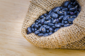 Beans in sack, on wood background