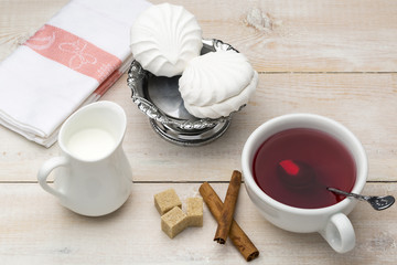 Black tea with milk. Cane sugar and cinnamon sticks