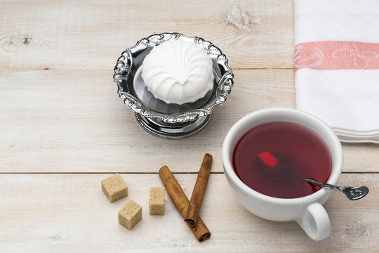 Cup of red tea. Cane sugar and cinnamon sticks with sweet dessert - Powered by Adobe