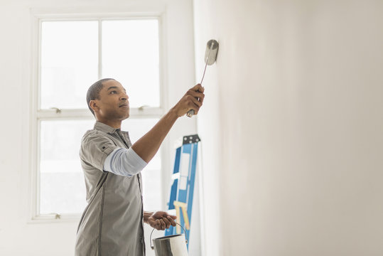 Black Man Painting Wall Of Home