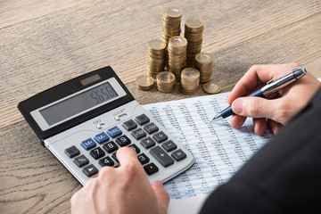 Close-up Of A Businessman Calculating Financial Report