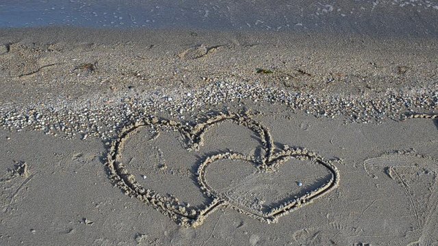 Two hearts on sand, the beach.