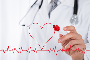 Doctor Drawing Heart Symbol Near Electrocardiogram