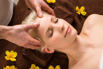 Obraz na płótnie Canvas Young Woman Receiving Head Massage At Spa