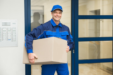 Deliveryman Standing Near Door Holding Box