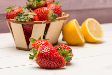 Strawberries in a small basket and lemon