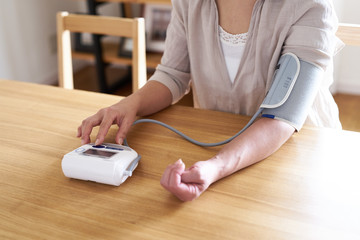 血圧を測る女性 - obrazy, fototapety, plakaty
