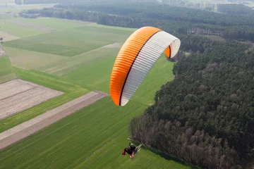 Abwaschbare Fototapete Luftsport Luftaufnahme eines Motorschirms, der über die Felder fliegt i