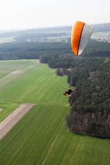 Cercles muraux Sports aériens aerial view of paramotor flying over the fields i
