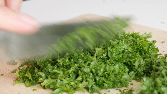 Parsley vegetable plant cutting with knife on smaller pieces 4K 3840X2160 UltraHD footage - Petroselinum crispum plant on cutting board 4K 2160p UHD video