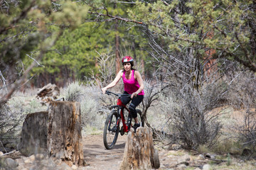 Fototapeta na wymiar Woman riding mountain bike on trail in forest