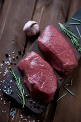 Rustic wooden cutting board with raw asado marbled beefsteaks