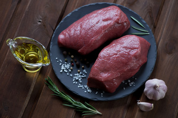 Basalt plate with fresh asado steaks ready to be cooked, closeup