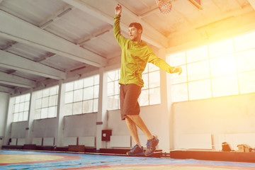 Man slacklining walking and balancing on a rope, slackline in a sports hall