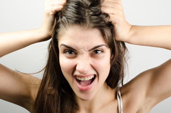 Closeup pose of an angry woman pulling her hair