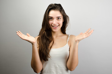 Portrait of young cheerful smiling woman, over grey background