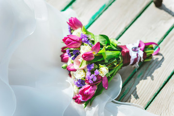 Wedding bouquet on a wooden pier. Purple white flowers.