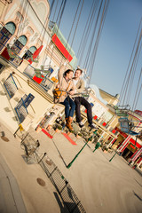 Young couple together on carousel in amusement park