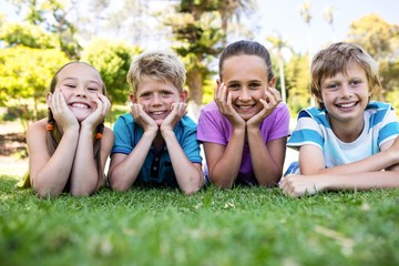 Happy children lying on grass
