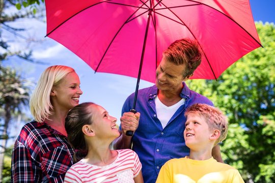 Family standing under umbrella