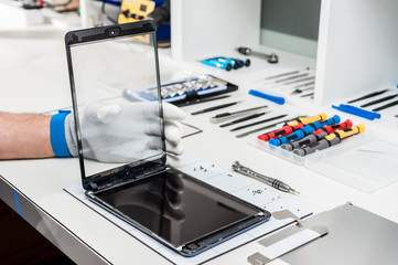 Close-up photos showing process of tablet device repair