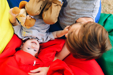Young happy father and resting with his young son on the pillows